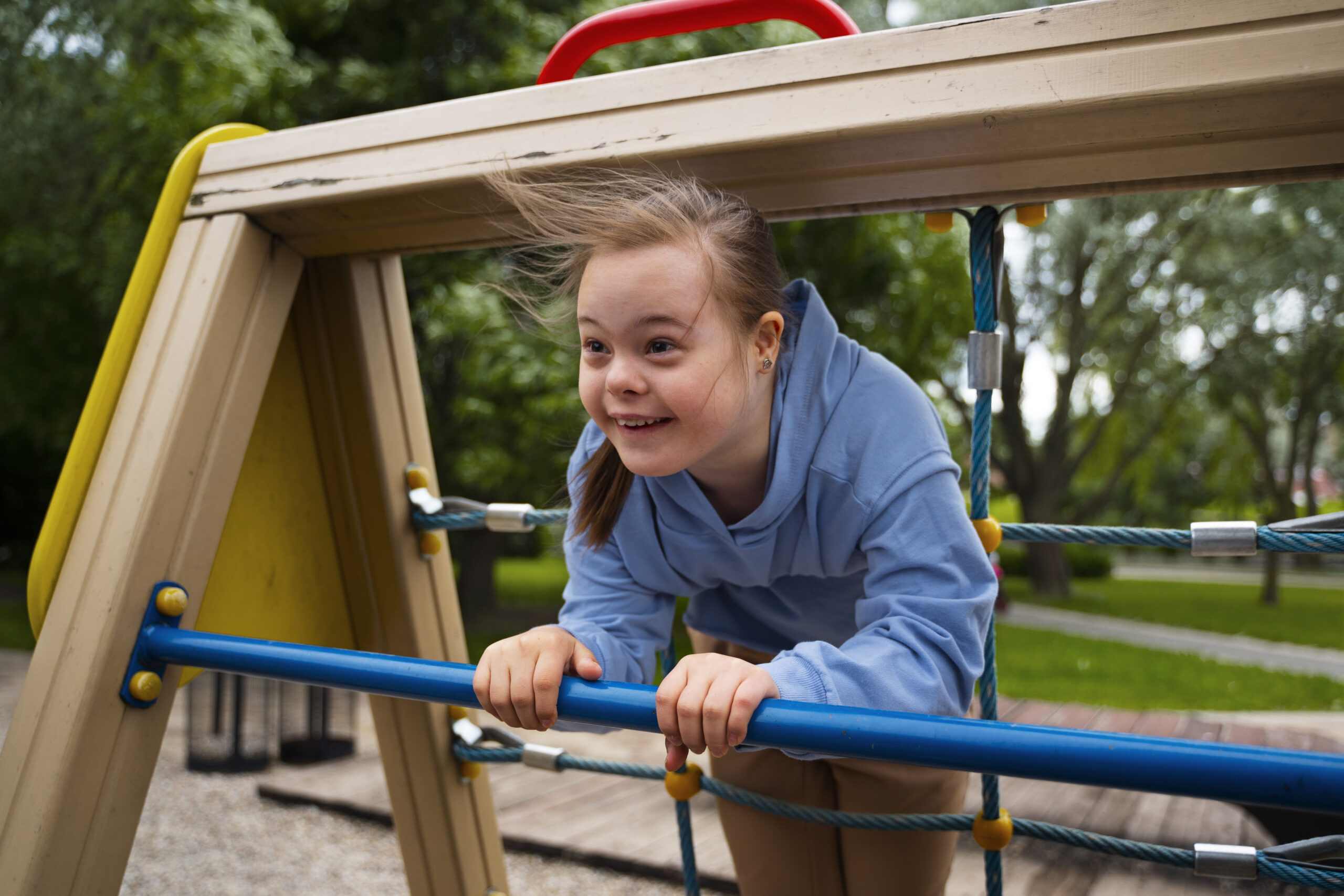happy child with down syndrome playing outside scaled